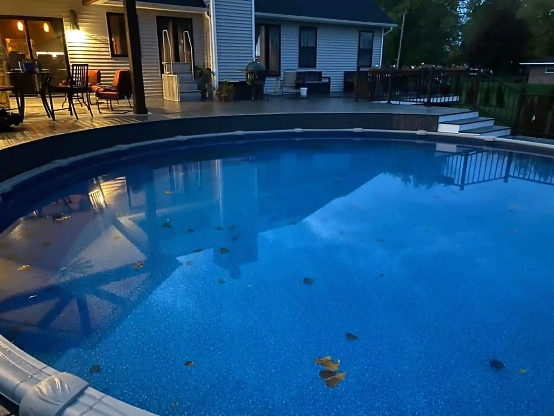 photo of a curved pool deck design idea with curved deck that is partially surrounded